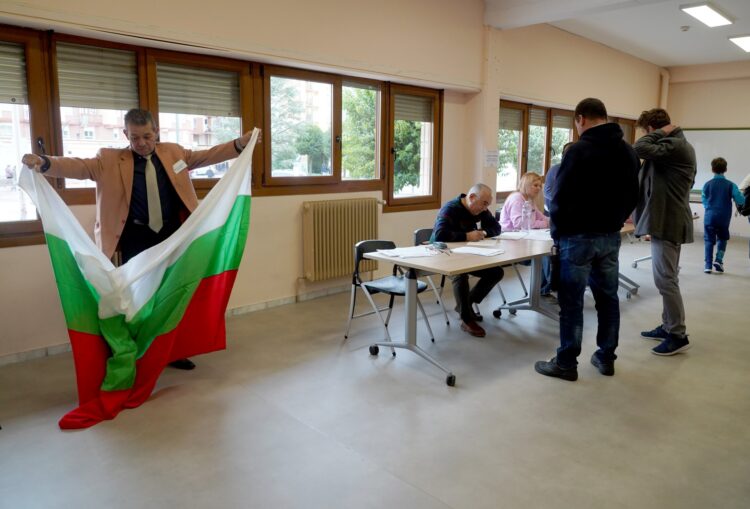 Un voluntario extiende una bandera de Bulgaria durante la votación en Valladolid./ ICAL