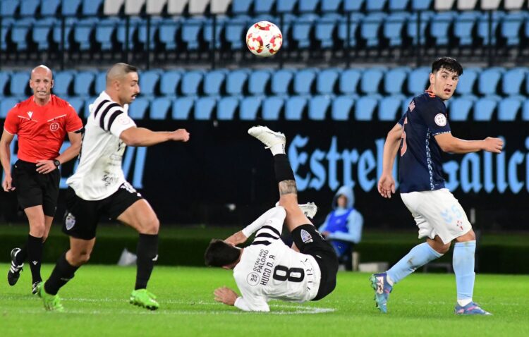 Hugo Díaz cae al suelo tras disputar un balón con un jugador del Celta Fortuna en un momento del encuentro./ JUAN MARTÍN-G. SEGOVIANA