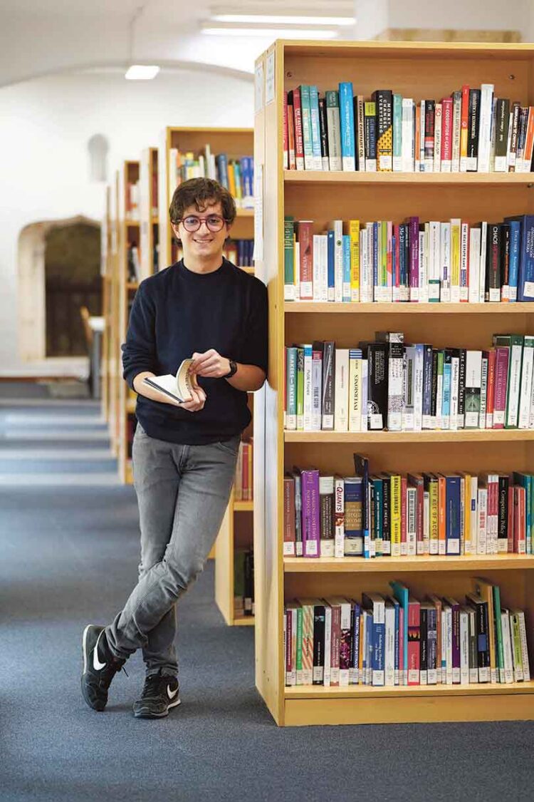 El estudiante ecuatoriano Lorenzo Rosania posa junto a su libro Espejismos en la biblioteca del campus de Segovia. / Roberto Arribas