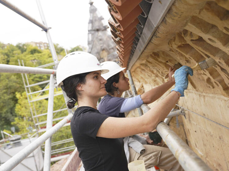 Las restauradoras trabajando en la decoración exterior del Campus de IE. / ROBERTO ARRIBAS