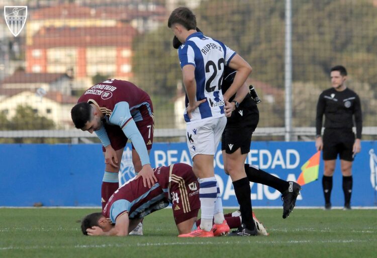 Berlanga intenta asistir a Fer Llorente, dolorido de un golpe con un contrario durante el partido ante la Real Sociedad B./ JUAN MARTÍN-G. SEGOVIANA