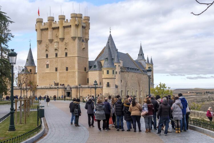 Turistas contemplando el Alcázar de Segovia.