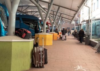 Imagen parcial de la estación de autobuses de Segovia, con usuarios esperando para subir a los vehículos y varias maletas apoyadas en las columnas./ KAMARERO