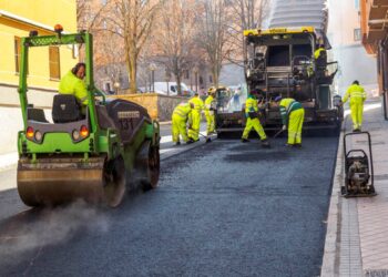Trabajadores en pleno proceso de asfaltado de una calle en Segovia.