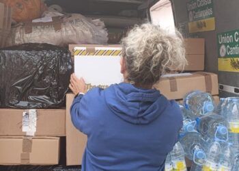 Una voluntaria carga la furgoneta con el material recogido / LOURDES MATARRANZ