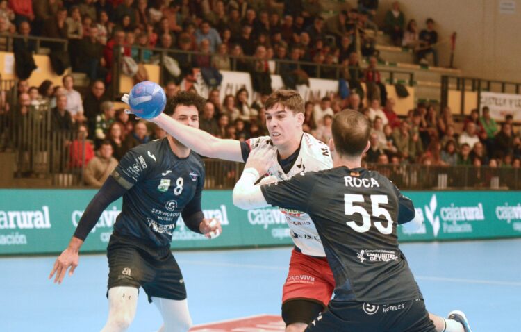 Un empate de orgullo 1 Mario Nevado intenta lanzar ante la oposición de un jugador del Benidorm./AMADOR MARUGÁN