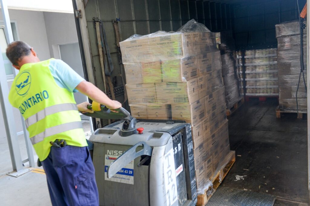 Un voluntario transporta lotes de comida. 