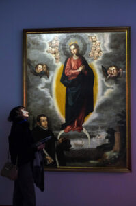 Imagen tomada durante la inauguración de la exposición, donde una visitante contempla la Virgen de la Inmaculada con el canónigo Mateo Vázquez de Francisco Pacheco, 1621.