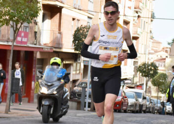 Un agente de Policía Local acompaña al grupo de cabeza en una anterior edición de la Media Maratón de Segovia. / A.M.