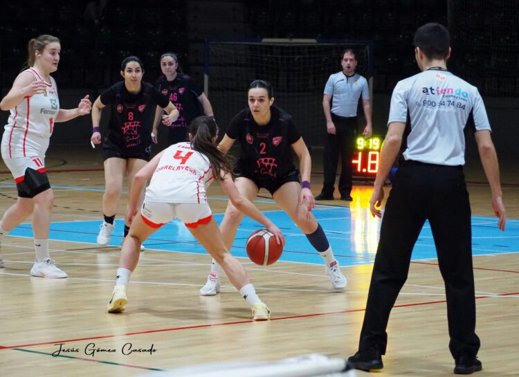 Una jugadora del Torrelavega conduce la pelota ante la presión de una rival del Cochinillo Segoviano./CD. SPORDEPORTE