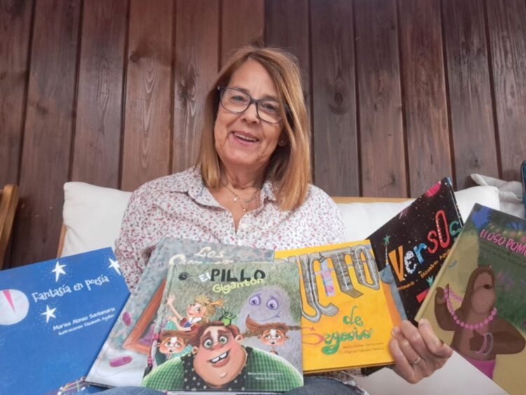 La escritora segoviana Marisa Alonso Santamaría mostrando diversos ejemplares de sus obras infantiles.
