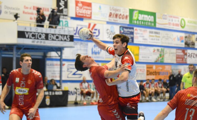 Mario Nevado intenta lanzar sobre un jugador del Bada Huesca./ AMADOR MARUGÁN