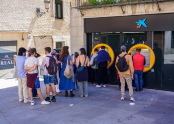 Usuarios haciendo cola junto a uno de los cajeros en el centro de la ciudad durante la jornada del lunes para sacar dinero en efectivo./ HÉCTOR CRIADO