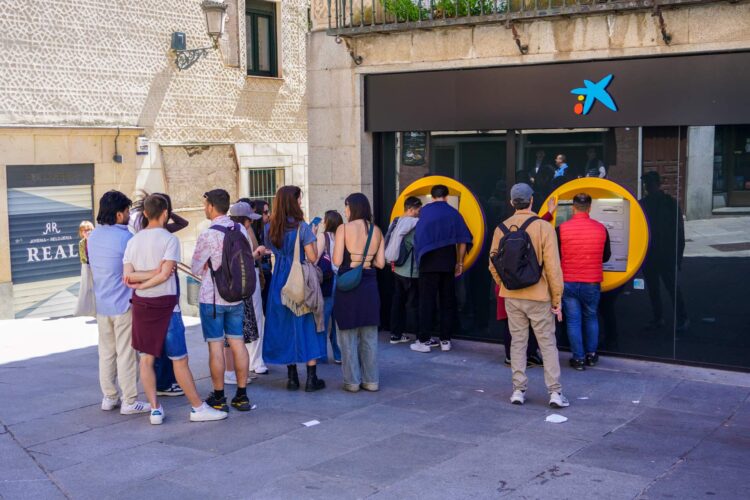 Usuarios haciendo cola junto a uno de los cajeros en el centro de la ciudad durante la jornada del lunes para sacar dinero en efectivo./ HÉCTOR CRIADO