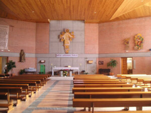 Interior de la nave de la iglesia de la Resurrección del Señor desde la entrada. Al fondo, en el presbiterio, la imagen de Cristo Resucitado. A la derecha San Mateo.