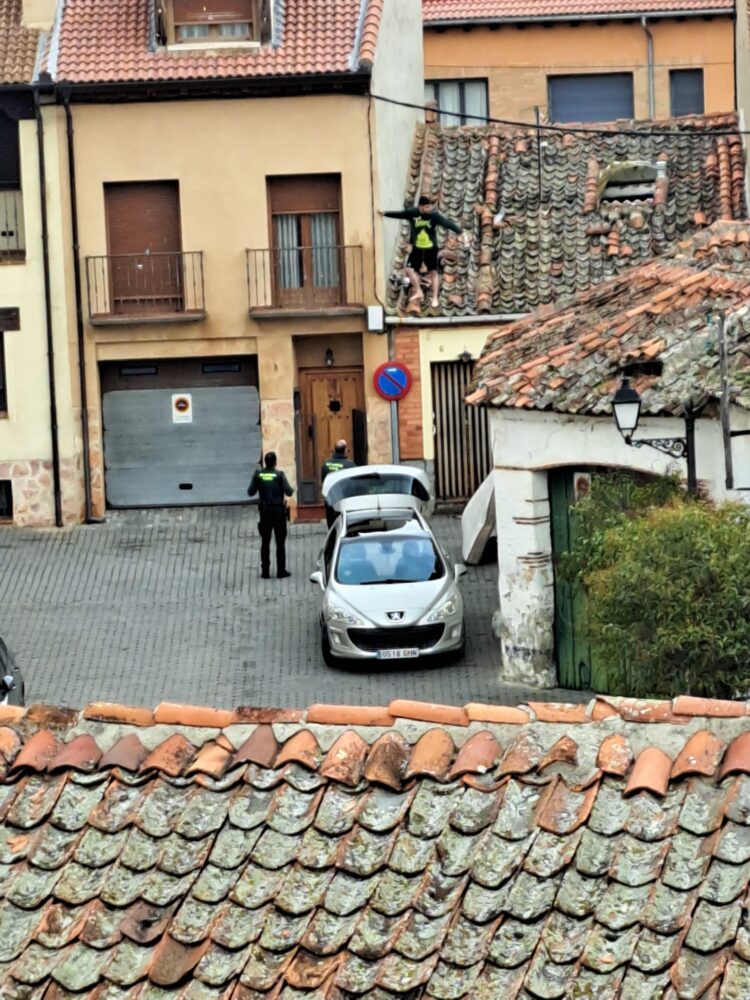 El joven, subido al tejado de su vivienda con los guardias civiles intentando hablar con él. / E.A.