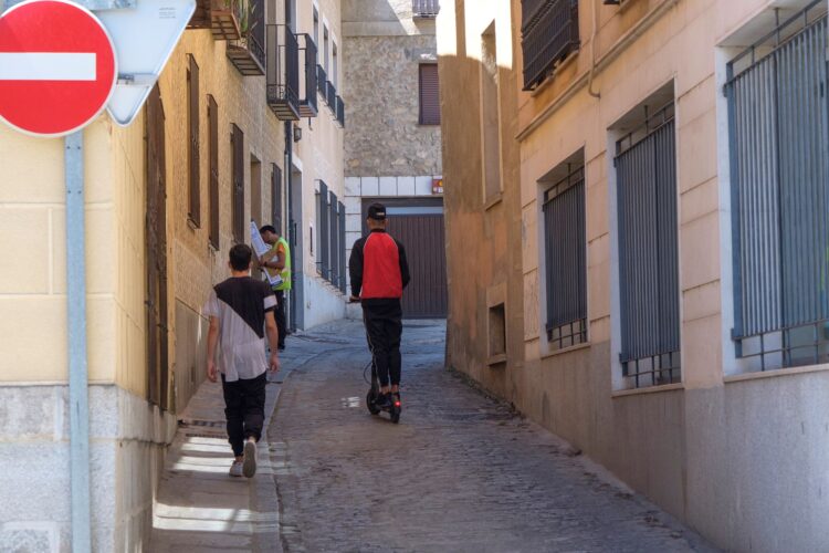 La falta de normativa clara sobre el uso del patinete llega a los tribunales 1 Un usuario de un patinete, ascendiendo por una calle de dirección prohibida en el centro de Segovia./ KAMARERO