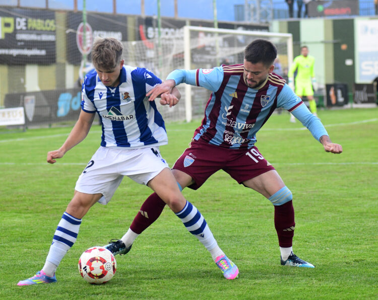 Josh Farrell y un rival pelean por la pelota en una acción del partido entre Segoviana y Real Sociedad ‘B’ celebrado en La Albuera./JUAN MARTÍN-G. SEGOVIANA
