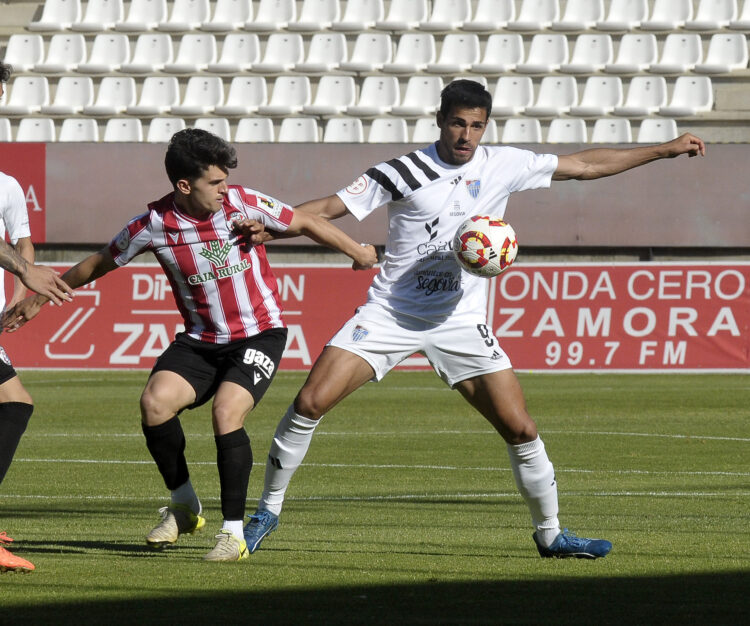 Diego Gómez protege la pelota ante la presión de un rival durante un instante del encuentro entre Segoviana y Zamora./JUAN MARTÍN-G. SEGOVIANA