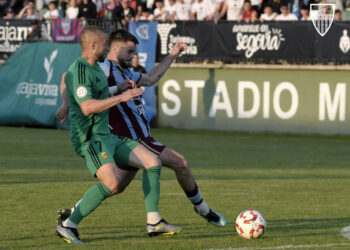 Josh Farrell pugna con un jugador del Nástic durante el encuentro de la pasada jornada celebrado en el campo municipal de La Albuera./JUAN MARTÍN-G. SEGOVIANA