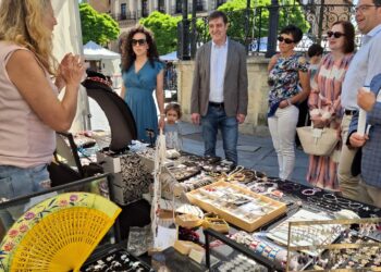 Los representantes institucionales escuchan las explicaciones de una de las participantes en la Feria./ CÁMARA COMERCIO