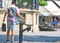 Una persona se refresca en una fuente durante un día de calor.