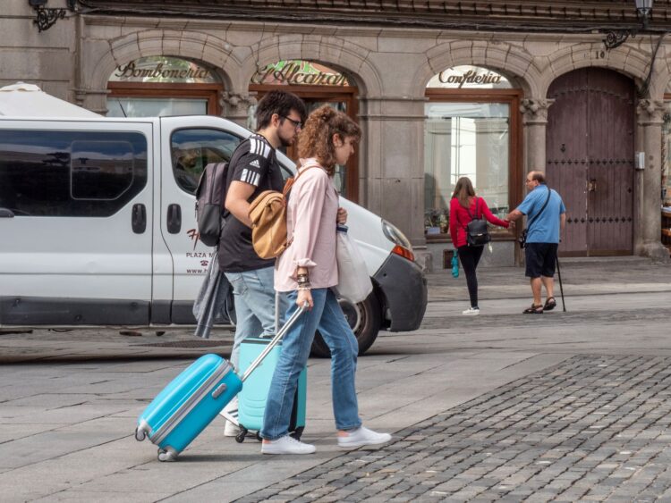 Cerca de 200 segovianos regresaron a su tierra durante el último año 1 Dos jóvenes con maletas cruzan la Plaza Mayor. /NEREA LLORENTE