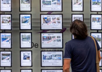 Un viandante observa las ofertas que aparecen en el escaparate de una inmobiliaria./ ICAL