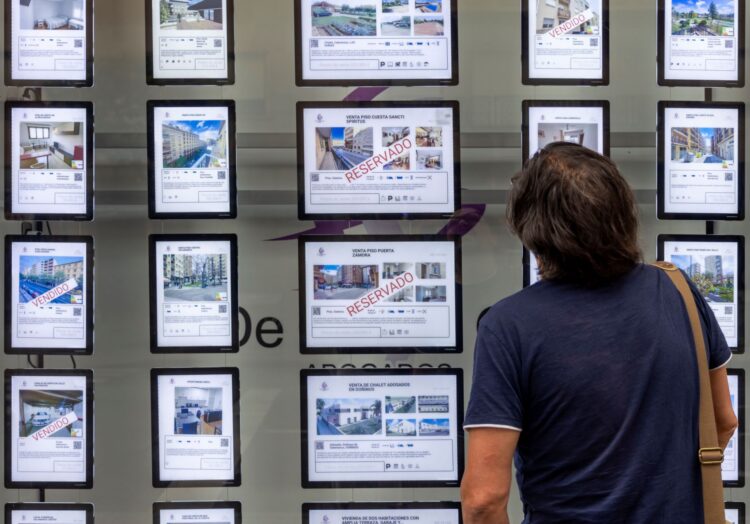 Un viandante observa las ofertas que aparecen en el escaparate de una inmobiliaria./ ICAL