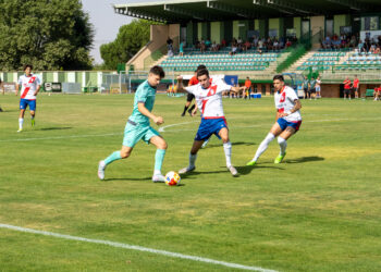Juanma conduce la pelota ante la presión de un rival en un instante del duelo entre Segoviana y Rayo Majadahonda./HÉCTOR CRIADO