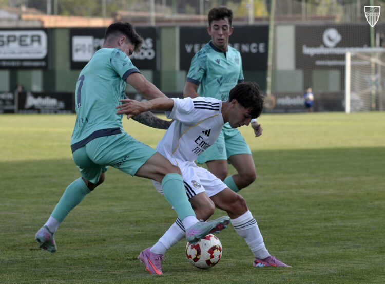 Juanma pugna con un rival en el duelo entre Segoviana y Real Madrid C./JUAN MARTÍN-G.SEGOVIANA
