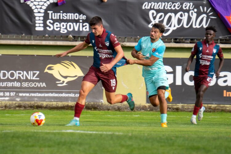 La Segoviana, a confirmar el buen inicio 1 René Pérez se escapa de la marca de un contrario, que le agarra de la camiseta para frenar su avance./ HÉCTOR CRIADO