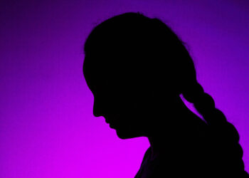 Silueta de una mujer sobre fondo morado. / NEREA LLORENTE