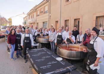 Cocineros, autoridades y comensales posan junto a las ollas de patatas con costillas./ E. A.