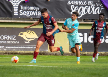 Un rival sujeta a René en una acción del partido entre Segoviana y Sámano./HÉCTOR CRIADO