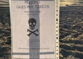 Un cartel avisa del peligro que supone la fumigación que se está realizando en la finca./ E. A.