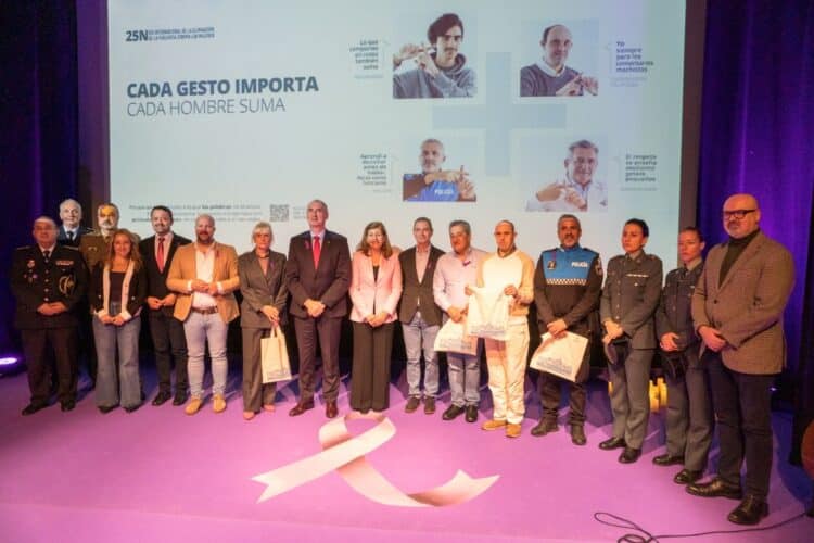 Foto de familia al final del acto del 25N con los cuatro segovianos “que suman” al fondo en la pantalla.. /Héctor Criado
