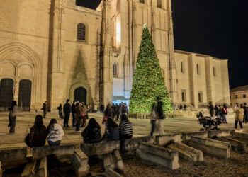 Los turistas se concentran frente a la fachada de la catedral para observar su iluminación nocturna.