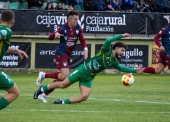 El juagdor del Atlético Astorga cae ante la presencia de Diego Campo durante el encuentro jugado en La Albuera./ HÉCTOR CRIADO