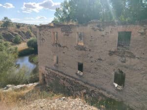 Vista exterior del molino, con el río Eresma al fondo.