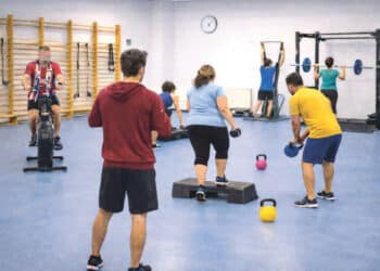 Unidad de ejercicio con varias personas practicando diferentes ejercicios.