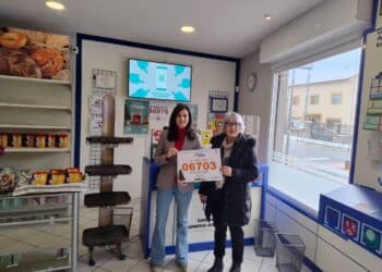 Paloma, con su hija Irene muestran el número vendido en su establecimiento, el primer premio.  / M. A. R.