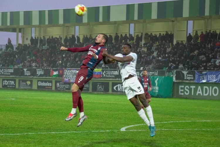Marc Tenas pugna con un rival por un balón aéreo durante un instante del encuentro entre Segoviana y Lealtad./HÉCTOR CRIADO