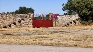 Unas viejas escaleras en el muro de piedra con su cancela.