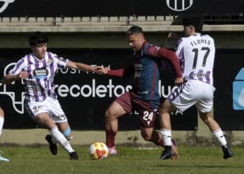 Pau Miguélez controla la pelota ante la presión de dos rivales en una acción de partido entre Segoviana y Valladolid Promesas./JUAN MARTÍN-G.SEGOVIANA