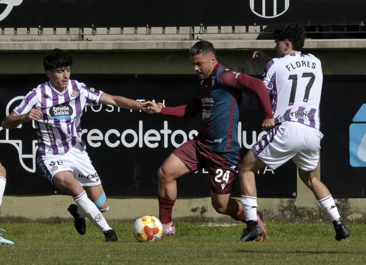 Pau Miguélez controla la pelota ante la presión de dos rivales en una acción de partido entre Segoviana y Valladolid Promesas./JUAN MARTÍN-G.SEGOVIANA