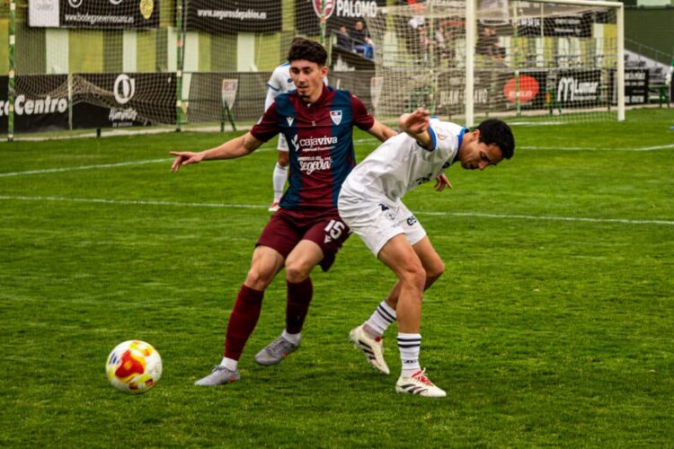 Rodrigo Ibañes pugna con un rival en un instante del encuentro entre Segoviana y Marino de Luanco celebrado en La Albuera./HÉCTOR CRIADO