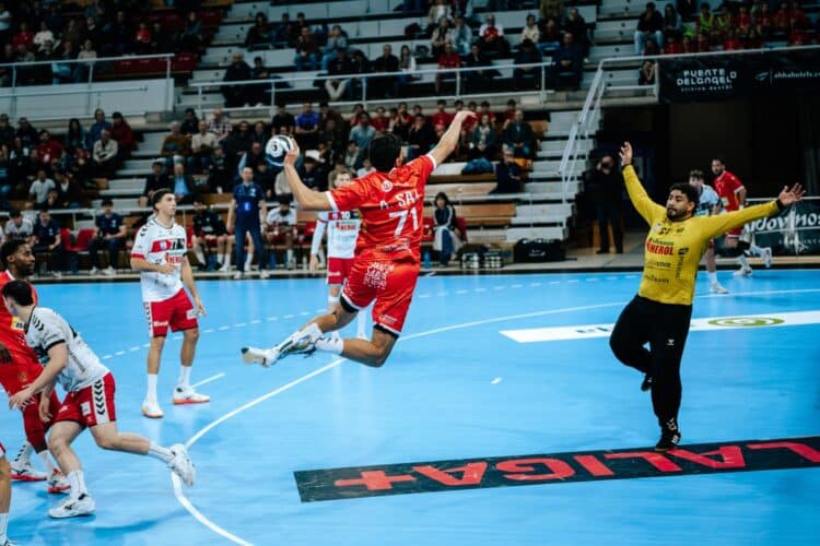 Mateus Buda intenta detener el lanzamiento de un rival durante el partido en Huesca./ JESÚS BARRABÉS