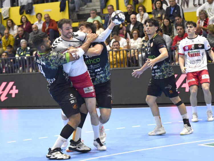 David Fernández pugna con dos rivales en un instante de partido entre BM Nava y Torrelavega./AMADOR MARUGÁN